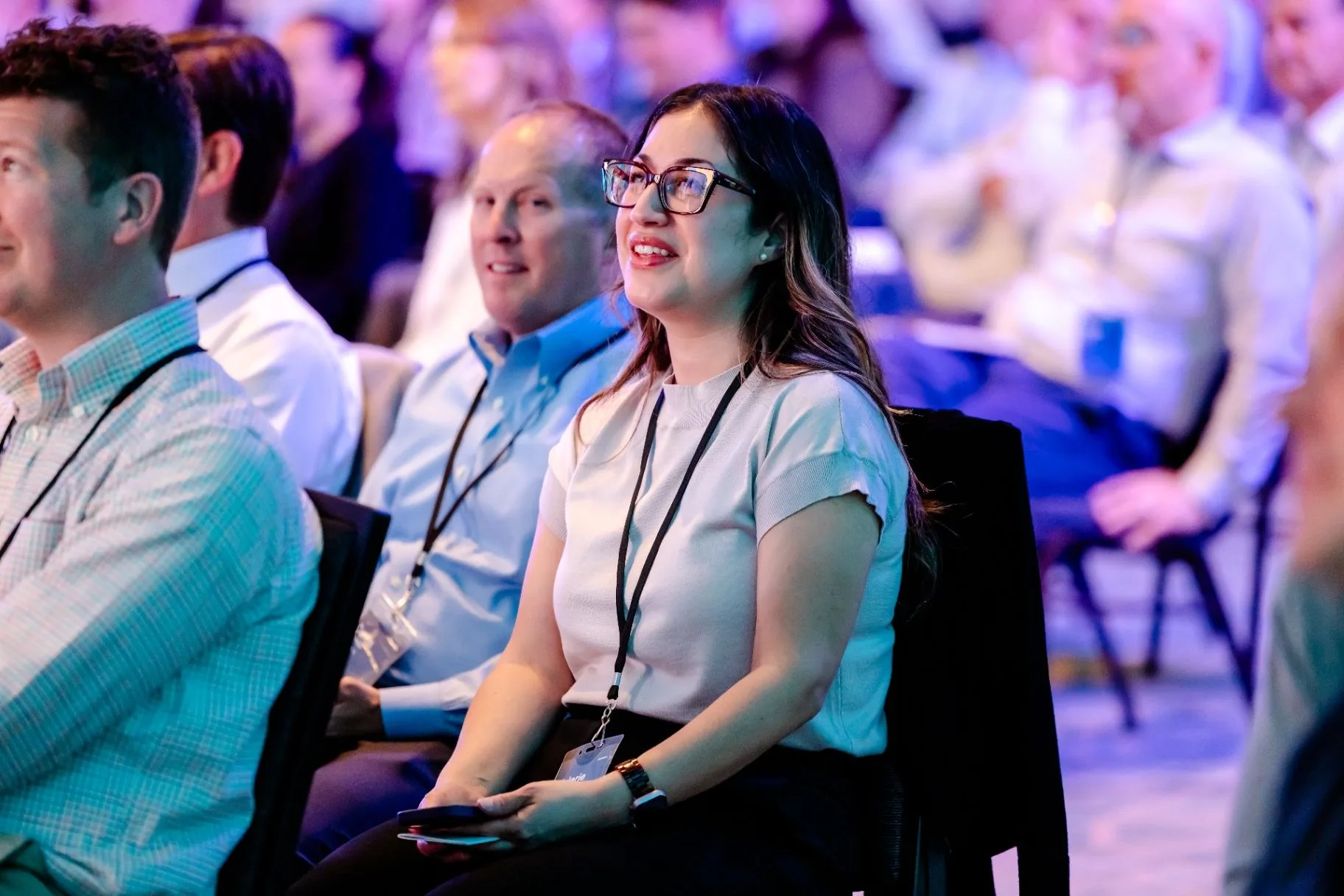 Attendee seated during a lit conference presentation
